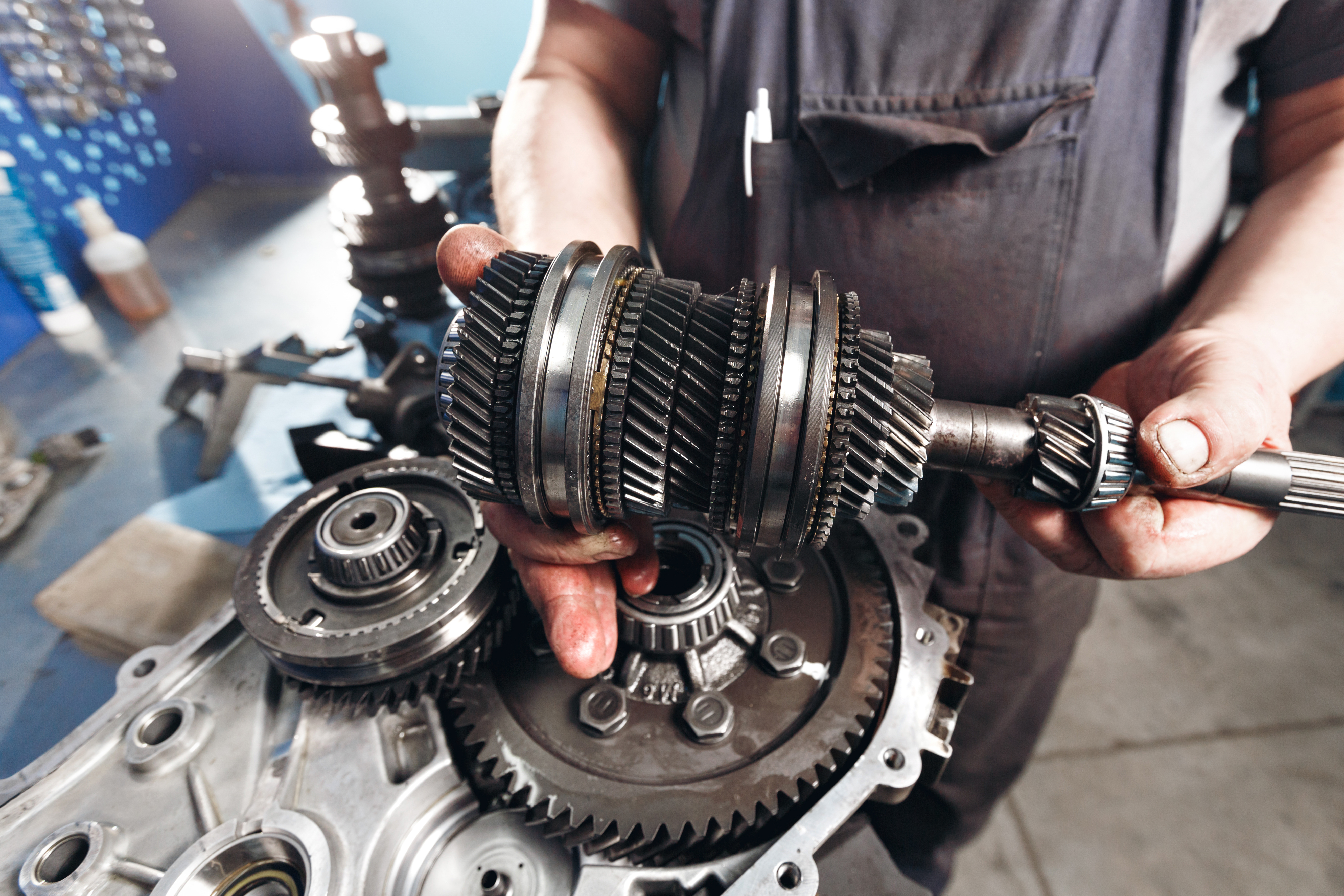 Transmission specialist inspecting gear assembly in shop