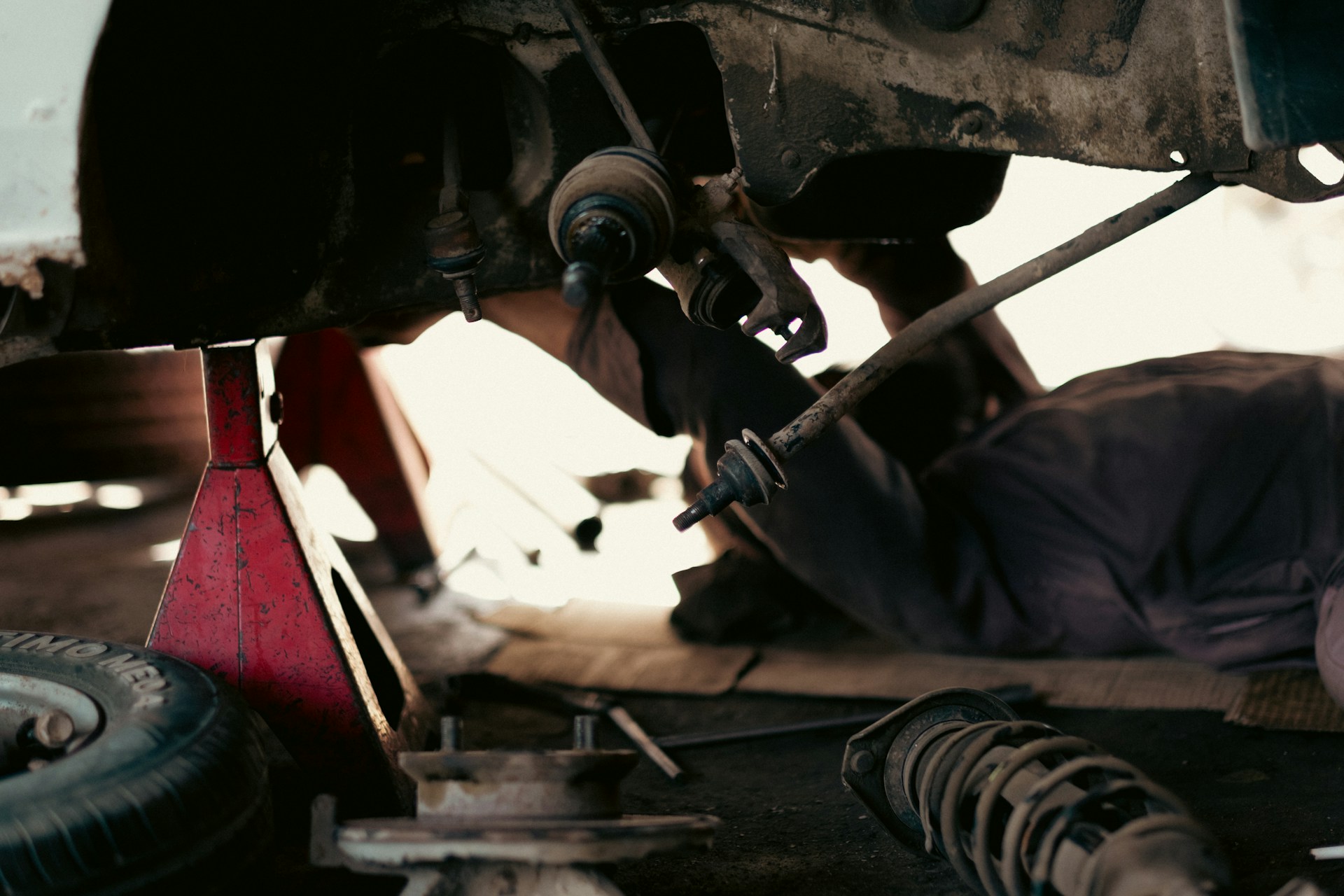 Technician servicing vehicle undercarriage